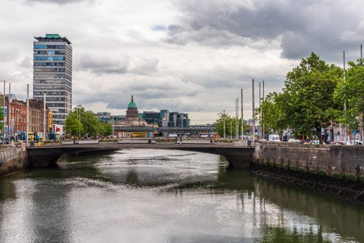 A bridge over the River Liffey with skyscrapers visible in the distance.