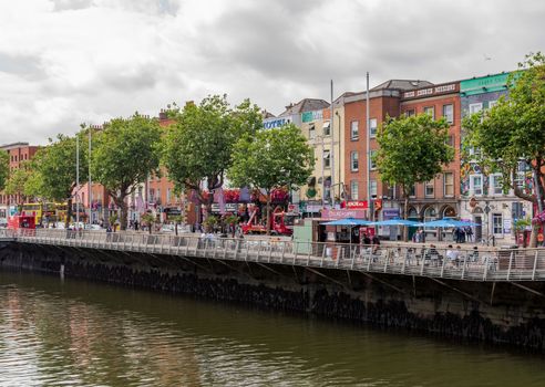 Dublin, Ireland -- July 9, 2018.  Colorful shops line the sidewalks on the banks of the River Liffey in Dublin, Ireland.