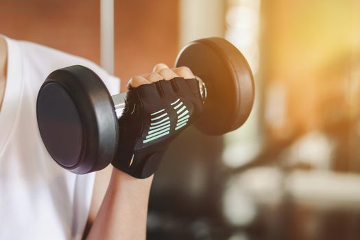 Close up woman are lifting dumbbells in the fitness room.