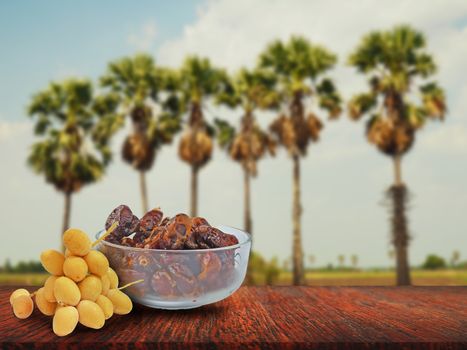 Display of fresh and dried dates on a wooden table With a blurred background.
Advertising and product display ideas.