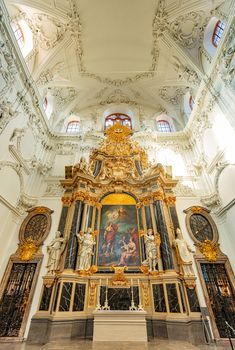 Old golden church altar in Wurzburg, Bavaria, Germany. Statues and white interior.