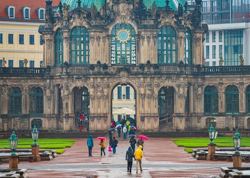 DRESDEN, GERMANY - SEPTEMBER 22, 2014: Dresden Zwinger in Germany, Saxony, Europe. People walking under umbrellas in rain