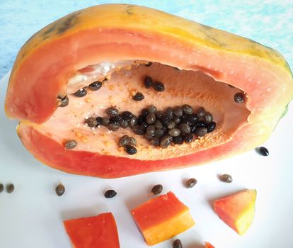Orange color fresh papaya kept in white background with cut pieces and rich in fibre Vitamin C and antioxidants Boosts your immunity Good for diabetics and eyes