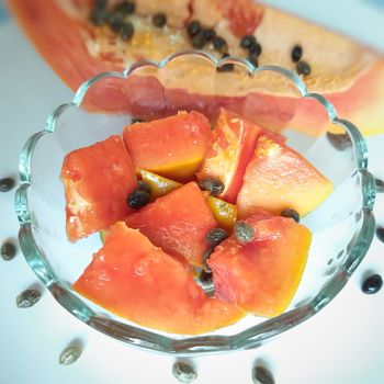 Orange color fresh papaya kept in white background with cut pieces in bowl and rich in fibre Vitamin C and antioxidants Boosts your immunity Good for diabetics and eyes