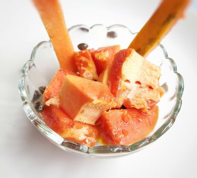 Orange color fresh papaya kept in white background with cut pieces in bowl and rich in fibre Vitamin C and antioxidants Boosts your immunity Good for diabetics and eyes