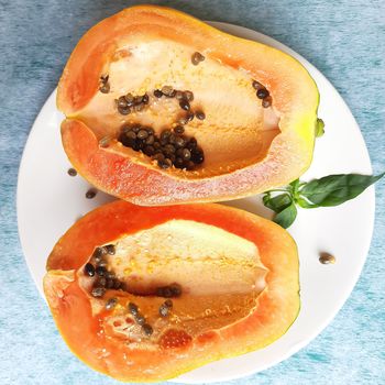 Orange color fresh papaya cut into half kept in white background and rich in fibre Vitamin C and antioxidants Boosts your immunity Good for diabetics and eyes
