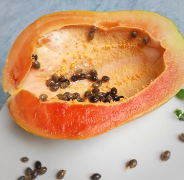 Orange color fresh papaya cut into half kept in white background and rich in fibre Vitamin C and antioxidants Boosts your immunity Good for diabetics and eyes