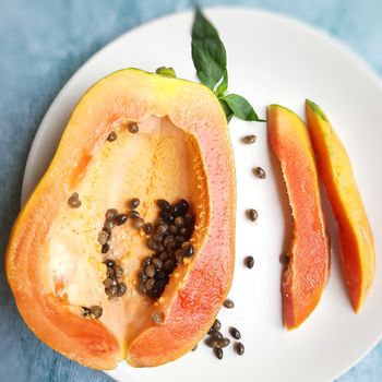 Orange color fresh papaya cut into half and cur pieces kept in white background and rich in fibre Vitamin C and antioxidants Boosts your immunity Good for diabetics and eyes