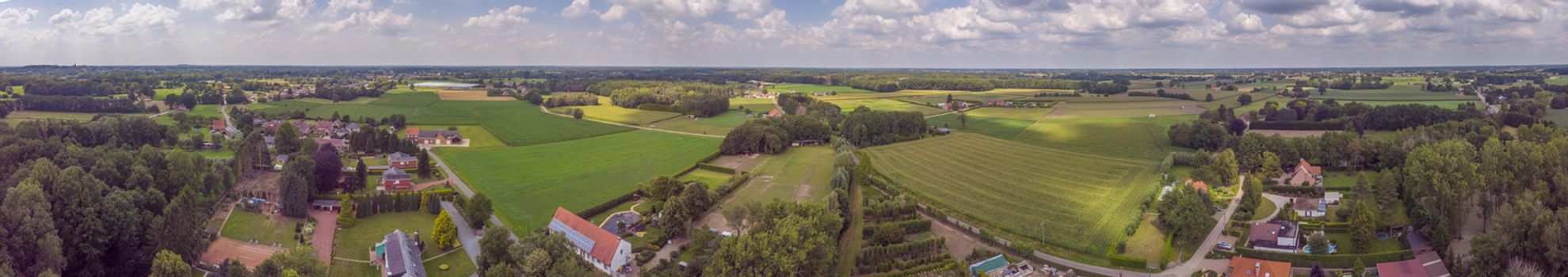Itegem, Belgium, July 2020: Aerial panorama view on a countryside area in Belgium Kempen area with houses and agricultural fields