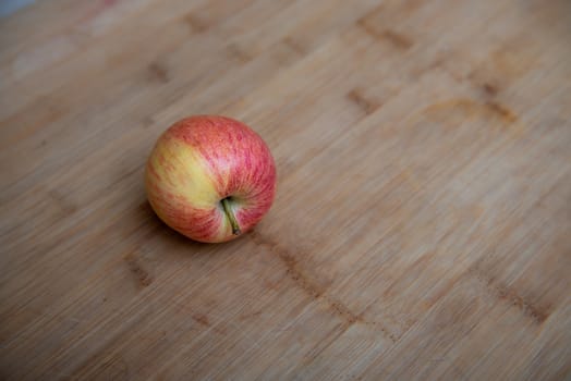 top view of one rustic apple on a wooden background