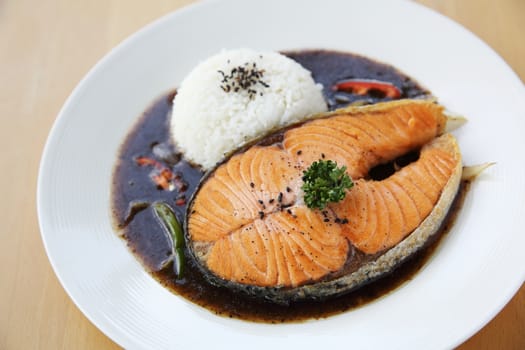 salmon black paper with rice on wood background
