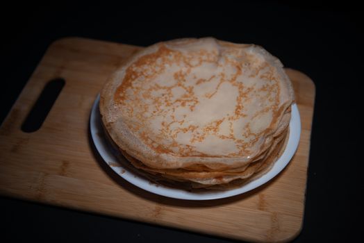 Top view of thin pancake on black background in pancake day