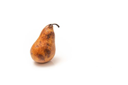 overripe pear with dark spots on a white background