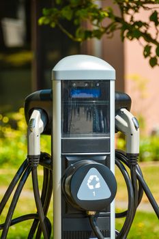 EV charger on bright sunny day. EV - electric vehicle charging station. Electric car charging point.