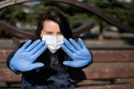 the girl, holding out her hands in rubber medical gloves and an anti-virus mask, warns that you need to keep your distance from her