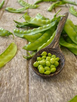 peas in wood spoon on wooden background