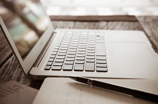 computer notebook on table in light vintage. soft focus