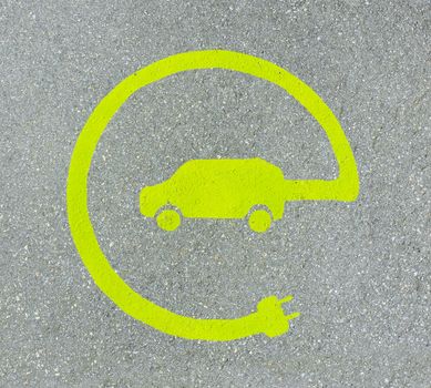 EV - electric vehicle charging station sign on asphalt. 'E' sign on asphalt texture