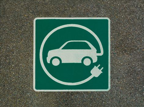 EV - electric vehicle charging station sign on asphalt. 'E' sign on asphalt texture