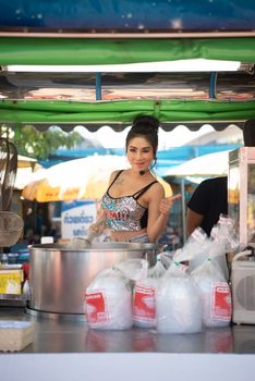 Samut Sakorn, Thailand - February 15, 2020 : Unidentified Asian sexy woman chef cooking a noodle soup with meat ball (kauy-tiew) for sale at Thai street food market or restaurant in Thailand