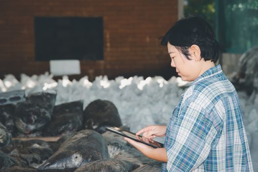 Asian woman smart farmer agriculturist working at Fertilizer composting plant with Organic Fertilizer, Compost (Aerobic Microorganisms) from animal waste for use in the organic agriculture industry