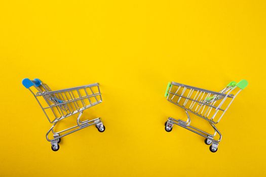 close-up of shopping trolley on yellow background with some copy space