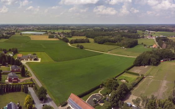 Itegem, Belgium, July 2020: Aerial panorama view on a countryside area in Belgium Kempen area with houses and agricultural fields