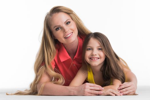 Mother and teenager daughter lying down isolated on white background