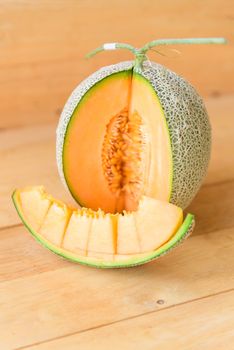 Fresh Orange melon on wood plate