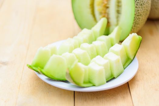 Fresh green melon on wood plate