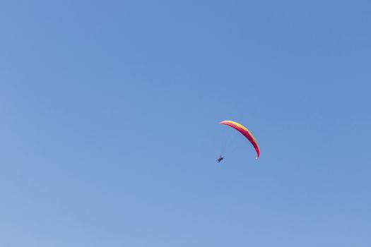 Colorful parachute aviator with blue sky. Paragliding in Cape Town, South Africa.