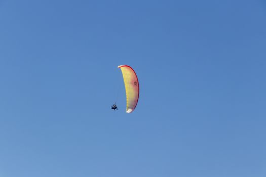 Colorful parachute aviator with blue sky. Paragliding in Cape Town, South Africa.