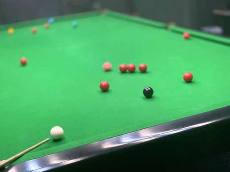 The snooker wooden cue, balls and table in indoor private room