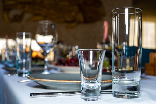 Table setting. Glass, stack, bowls and fork on the table. Cutlery on a white tablecloth