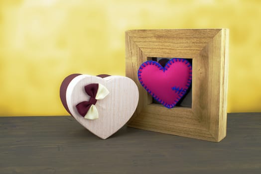 Handcrafted pink heart in a wooden frame with a heart shaped gift box