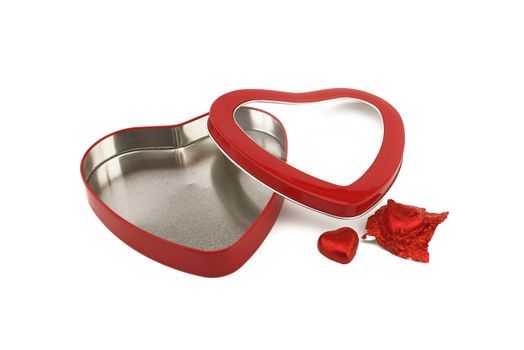Red heart shaped box with chocolate candy on a white background with copy space symbolic of love and romance for Valentines