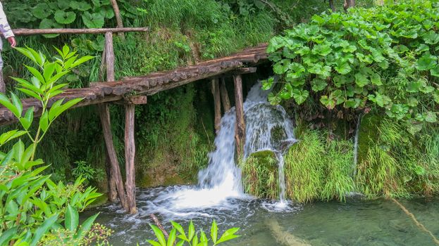 the wooden park pathways enjoying the view of emerald lakes, cascades and crystal clear water, Plitvice Lakes National Park, Croatia.