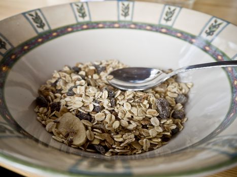 Breakfast cereal in the dish with a spoon.