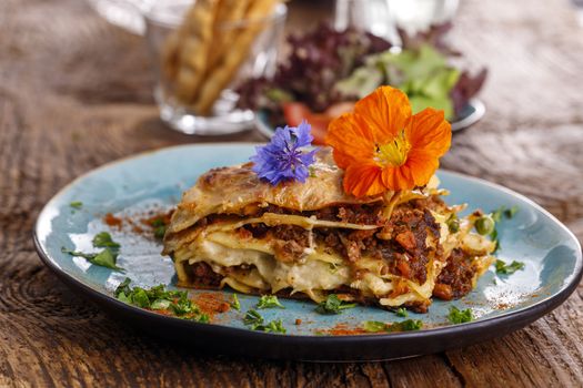 fresh lasagna on a blue plate