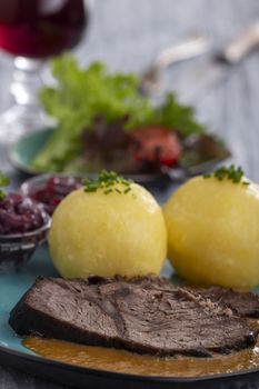 german sauerbraten on a plate with dumplings