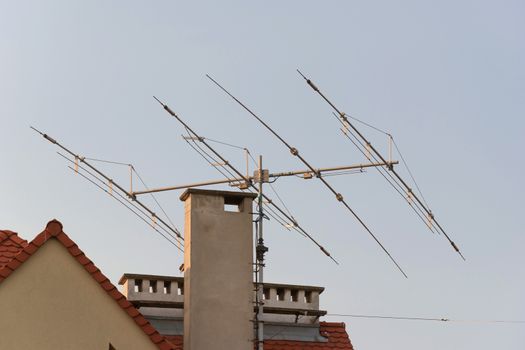 Tv antenna on roof of home. Technology of broadcast television and radio on rooftop. Signal receiver. Tower of transmit media. Residential roofing with mast of analogue antena. urban   Photography 