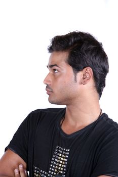 A portrait of a young Indian guy lost in thoughts, on white studio background.