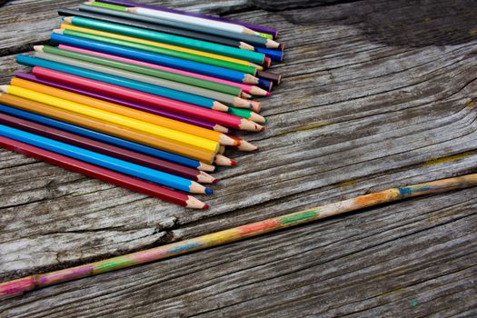 Drawing in the nature with colored pencils on wooden table. Paintings on a bamboo stick.