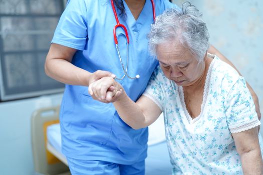 Asian nurse physiotherapist doctor care, help and support senior or elderly old lady woman patient at hospital ward : healthy strong medical concept.