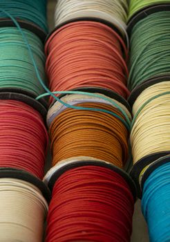 Close up many colorful craft lacing spools on retail display, high angle view