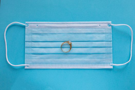Wedding rings with surgical mask facemask - weddings and divorce metaphor in covid-19 pandemic time