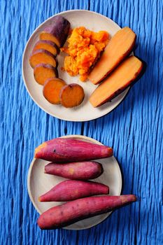 Sweet Potato on wooden cutting board with blue wood background