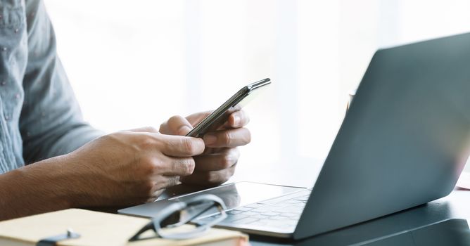 Close up businessman using smart phone at office.