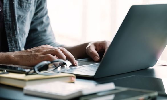 Close up businessman using laptop computer at home.