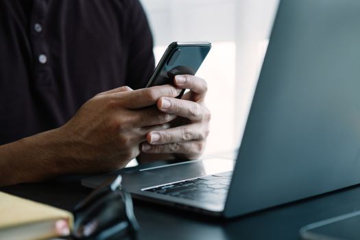 Close up man using smart phone at home.